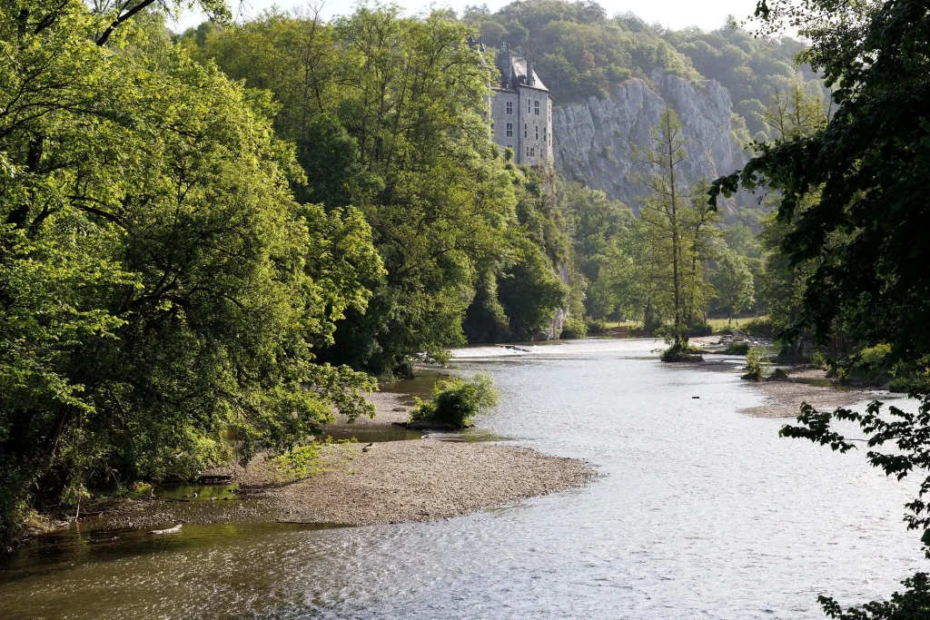 River landscape of the Lesse valley with historic riverside architecture.